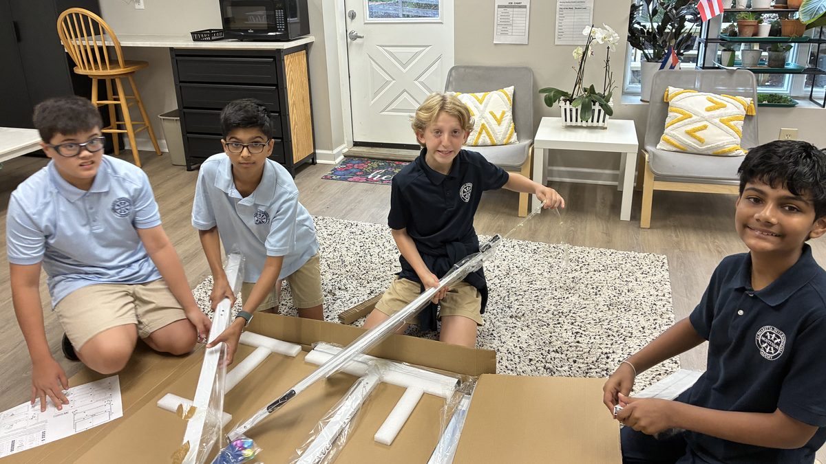 Four Middle School students working together on the floor of their classroom